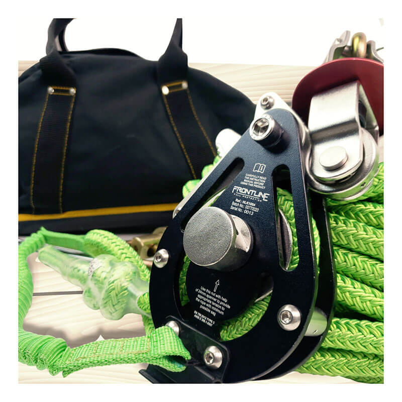 Close-up of the Frontline 4-Person 100' Adjustable HL System with 6' Anchor Straps by Frontline Fall Protection on a bright green rope; a black bag with brown handles is in the background on a light wooden surface.