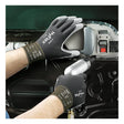 Wearing Ansell HyFlex Polyurethane Coated Glove 11-600 by Ansell, which features a durable polyurethane coating and a comfortable nylon knit liner, an individual uses a power tool to assemble or repair the interior panel of a car door.