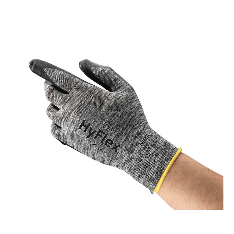 A hand wearing an Ansell HyFlex Nitrile Foam Glove 11-801, featuring a gray design with black fingertips, a foam nitrile coating for enhanced grip and durability, printed safety symbols, and a yellow cuff. This glove from Ansell offers superior comfort and flexibility thanks to its knitted variable stitch design.