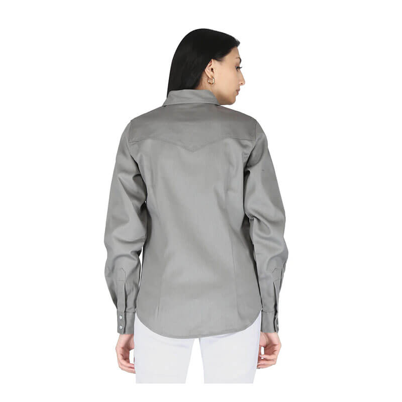 A woman with straight dark hair wears the ForgeFR Ladies Solid Snap Shirt LFRSLD in gray and white pants, standing with her back to the camera against a plain white background, highlighting stylish modern flame resistant workwear.