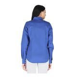 A woman with long dark hair, dressed in the ForgeFR Ladies Solid Snap Shirt LFRSLD in bright blue and white pants, stands with her back to the camera against a plain white background—showcasing modern women’s workwear.