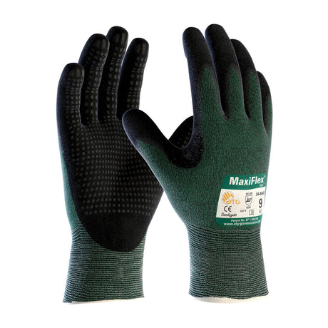 The PIP MaxiFlex Cut Nitrile gloves, 34-8443, featuring a textured MicroFoam grip, are showcased in black and green. Displayed in a standing position to reveal both front and back views, they are ideal for demanding tasks due to their superior protective qualities and touchscreen compatibility.