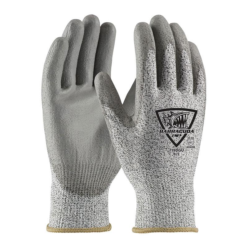 A pair of PIP Barracuda Polykor gloves featuring a polyurethane coated flat grip on the palms and a barracuda logo on the back. The beige cuffs indicate they are industrial work gloves with cut resistance for enhanced safety.