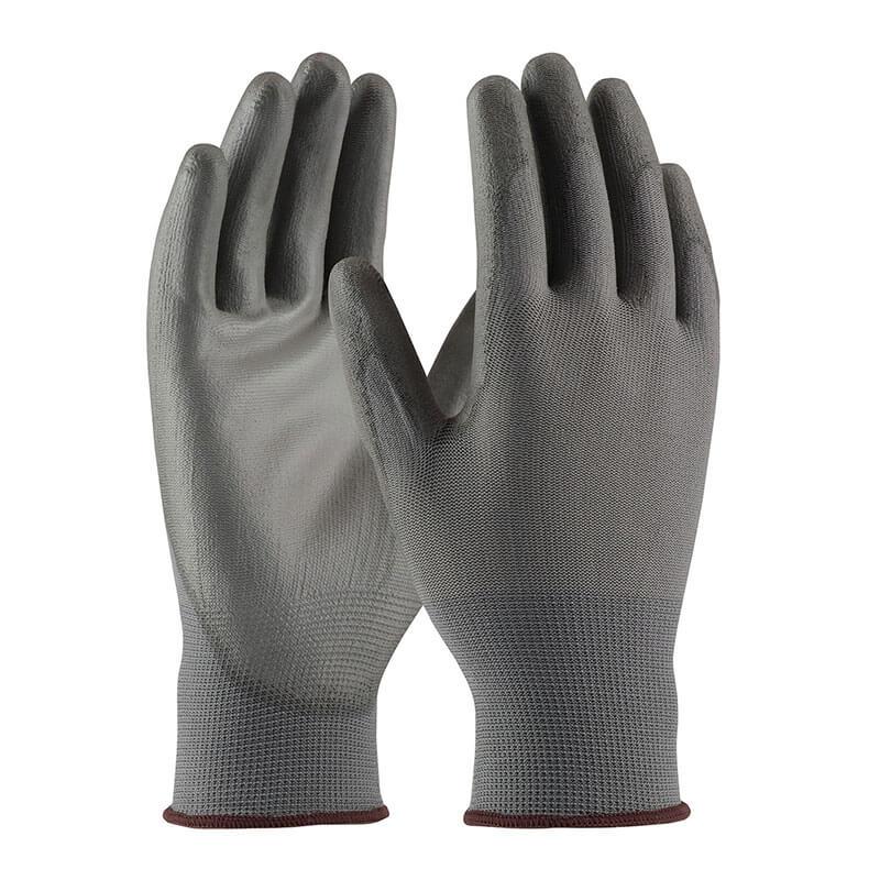 The PIP Knit Polyester Glove w/PU Coated Flat Grip 33-G115 by Protective Industrial Products showcases a seamless knit polyester design in gray with a textured surface. Its polyurethane-coated flat grip ensures durability, making it perfect for tasks that require excellent protection and secure handling.