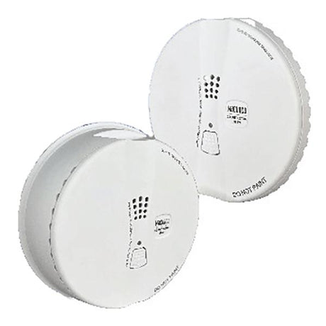 Two Macurco Residential Round Mount CO Gas Detectors, model CM-E1-R_, are displayed at a slight angle, showcasing their side profiles. These white, round detectors feature small vents and brand labeling on their surfaces and include a low-voltage carbon monoxide monitor for improved safety.