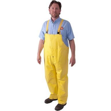 A man is standing on a plain white background, wearing the MCR Safety Concord FR Premium Neoprene Rain Bib Pants 800BP in yellow, featuring adjustable suspenders over a light blue shirt for added safety. He has paired them with brown shoes to complete his look.