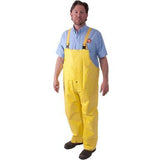 A person wearing MCR Safety Concord FR Premium Neoprene Rain Bib Pants 800BP in yellow, along with a light blue shirt, is standing on a white background.