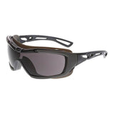 The MCR Hydroblast HB5 Series Safety Glasses by MCR Safety feature a sleek, modern design with dark tinted lenses and a black, angular frame. Ideal for sports or outdoor activities, these safety glasses offer UV protection and have an intricate temple design with splash-resistant features to enhance your experience in any condition.