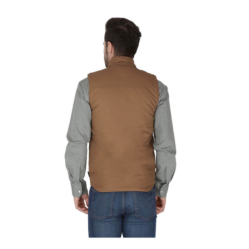 A man with short brown hair, seen from behind in a ForgeFR Forge FR Canvas Duck Vest MFRVST-001 over a patterned long-sleeve shirt and blue jeans, stands against a white background, showcasing the durability of modern flame resistant workwear.