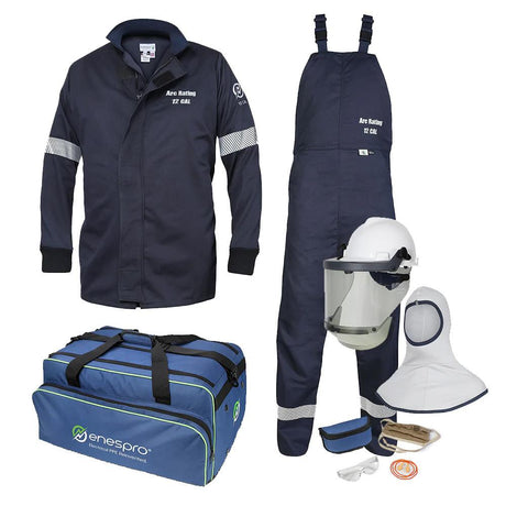 The protective gear set includes a navy NSA 12 Cal Enespro Arc Flash Jacket & Bib Overalls Kit EN12KTWUNB03_ _, along with a helmet featuring a face shield. Accessories consist of gloves, safety glasses, ear plugs, a hood, and a blue carrying bag with the "enespro" logo. The jacket complies with NFPA 70E safety standards.