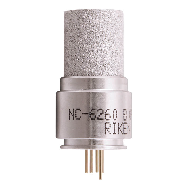 A close-up of a cylindrical sensor with metallic finish, akin to the RKI Eagle 2 Replacement LEL Sensor NC-6260B by RKI Instruments. It has a textured top, protruding pins at the bottom, and markings reading "NC-6260 B" and "RIKEN".