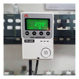 The RKI Instruments OX-600 Indoor Stand Alone Oxygen Monitor (72-100_) uses a galvanic cell sensor, displays 20.9% on its green screen, has Mode and Set buttons, bottom cables, and is mounted on a metal surface.