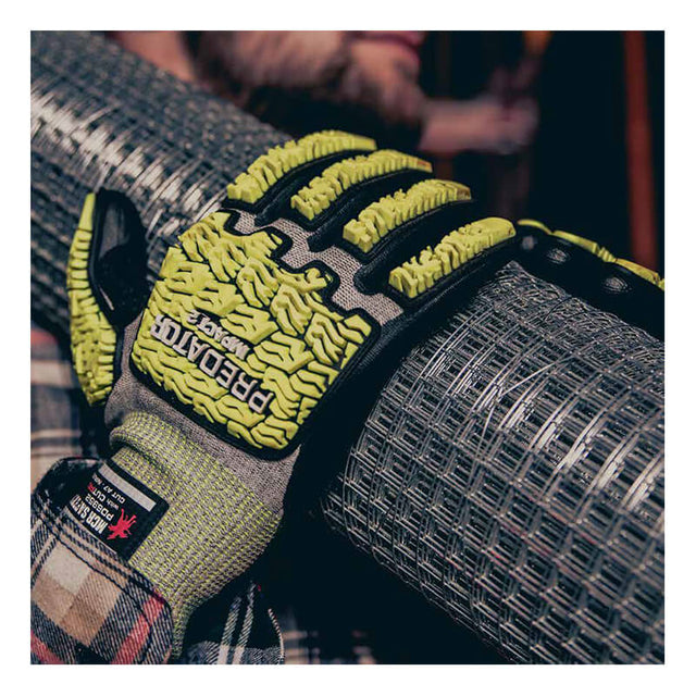 A person wearing MCR Safety Predator Hi-Vis Mechanics Gloves with HyperMax (PD6952) is gripping a roll of metal wire mesh. The yellow and black impact-resistant gloves feature textured padding and have the “Predator” brand name visible on the back.
