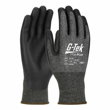 The image shows two cut-resistant gloves in black and gray from PIP - Protective Industrial Products, labeled "PIP G-Tek PolyKor X7 16-377". The gloves display logos and text that highlight their high level of cut resistance and the materials used. Designed with a seamless knit pattern, they have coated palms for improved grip and are touchscreen compatible, providing superior protection.