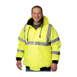 A person is showcasing the PIP Bomber Jacket with Zip-Out Fleece Liner 333-1762 by PIP - Protective Industrial Products. The bright yellow, high visibility jacket features durable construction with reflective stripes, a waterproof design complete with a hood, and black cuffs. The individual is smiling against a plain white background.