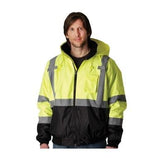 A person wearing a PIP Waterproof Reflective Value Bomber Jacket 333-1766, which features a yellow and black high-visibility design along with a hood and zip-up front, smiles while facing forward. This jacket, an ANSI Class 3 product from PIP - Protective Industrial Products, is crafted to ensure safety and visibility against the plain white background.