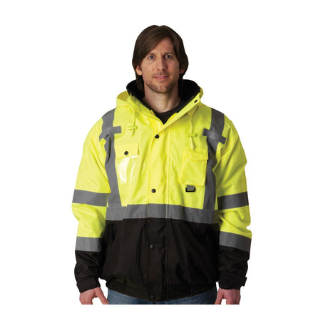 A person wearing an ANSI Type R Class 3 high-visibility jacket with reflective stripes stands facing forward. The PIP Rip Stop Premium Plus Bomber Jacket, Fleece Liner, D-Ring 333-1770 by Protective Industrial Products is yellow and black, featuring a hood and several pockets. Its waterproof outer shell contrasts against the plain white background.