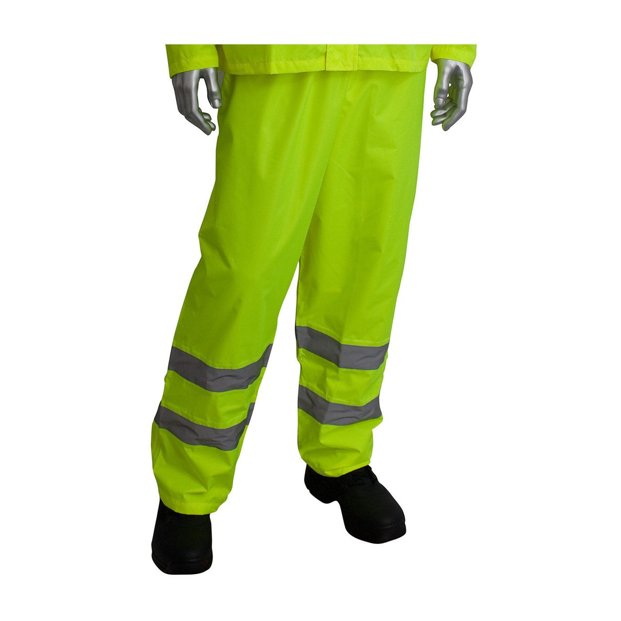 A mannequin dressed in the PIP Hi-Visibility 2-Piece Reflective Rain Suit 353-1000 showcases vibrant neon yellow rain pants with reflective silver bands around the legs, paired with black shoes. This ANSI 107 compliant ensemble from PIP - Protective Industrial Products ensures maximum safety and visibility in wet conditions.