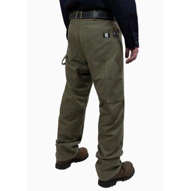 A person is shown from behind wearing GRIT FR Carpenter Pants in Green Duck and sturdy brown boots against a white background. These pants, from the GRIT FR Workwear brand, are crafted from 8.5 oz. fabric and feature multiple pockets along with a utility loop, making them ideal for work wear. Completing the outfit is a dark shirt, adding to the ensemble's rugged practicality.