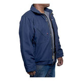 A man stands slightly to the side, wearing a GRIT FR Insulated Field Jacket in blue from GRIT FR Workwear, featuring quilt-lined insulation and buttoned pockets. Paired with casual jeans, he is set against a plain white background, showcasing both style and practicality.