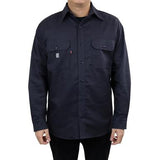 A person wearing a navy flame-resistant shirt from GRIT FR Workwear stands against a white background. The GRIT FR Twill Work Shirt is adorned with small embroidered logos above its two breast pockets. They face forward, hands by their sides, showcasing a blend of style and safety.