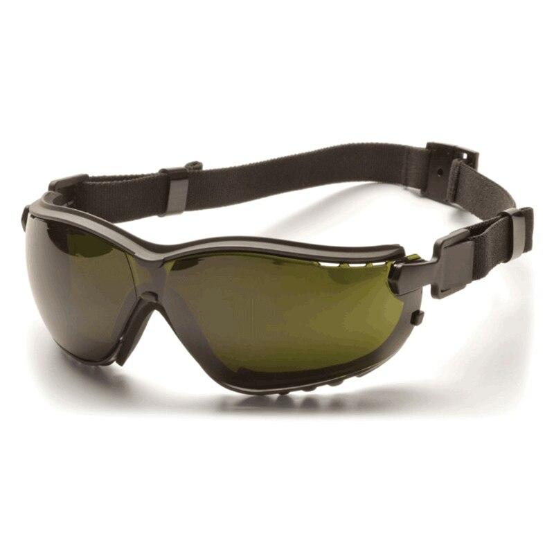 A pair of Pyramex V2G Welding Safety Glasses GB18_0SFT, featuring black frames and dark-tinted lenses with an adjustable elastic strap, rests on a light surface. Designed by Pyramex Safety for optimal protection, these goggles offer UV protection and an IR filter lens to ensure eye safety across diverse environments.