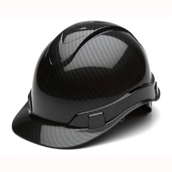 The Pyramex Safety Hydro Dipped Ridgeline Cap Style 4Pt Ratchet hard hat boasts a shiny black carbon fiber finish with a low profile design and curved brim. It features adjustable straps, a reflective surface that enhances the textured pattern, and 4-position harness points for a secure fit.