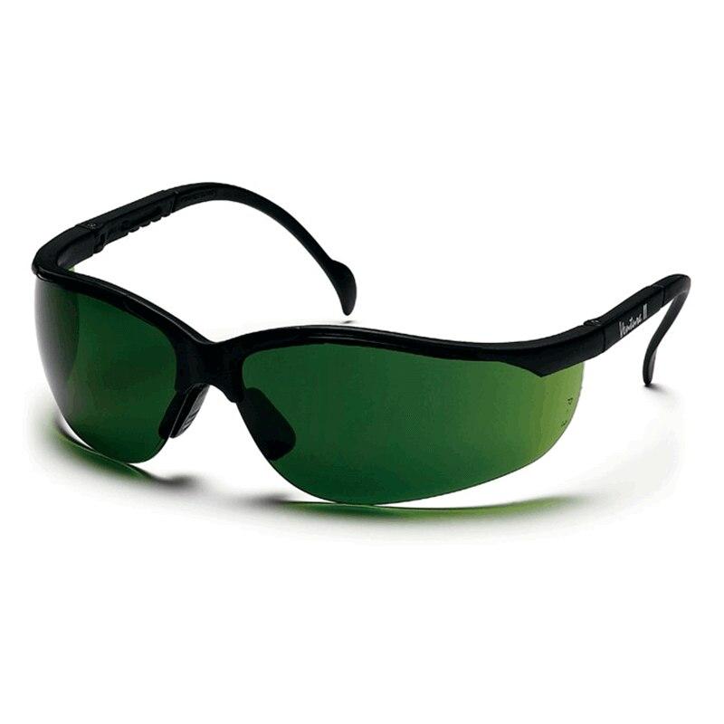 The Pyramex Venture II Welding Safety Glasses SB18_0SF by Pyramex Safety are showcased against a simple white backdrop. These glasses feature a stylish, wrap-around design with a dark green lens and black frames, providing complete eye coverage. They offer UV protection and come equipped with an IR filter lens for superior safety.