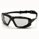 A pair of Pyramex Highlander Plus H2X Anti-Fog Safety Glasses with clear, scratch-resistant polycarbonate lenses, offering UVA/B/C protection and featuring an adjustable strap, rests on a white surface.