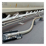 The UltraTech Pellet Pond 8859 by UltraTech is placed under connections where a large industrial hose meets metal piping beside a train car, providing spill and plastic pellet containment on an asphalt surface.