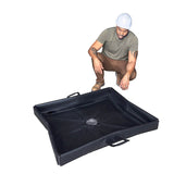 A man wearing a hard hat, green t-shirt, and brown boots crouches next to the UltraTech Pellet Pond 8859, a black containment tray with raised edges and handles, by UltraTech, set against a white background.