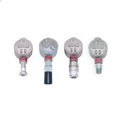 Four RKI Instruments S2 Fixed Gas Sensors/Transmitters with circular tops and varying cylindrical bases are aligned against a white background. Each sensor, crafted with explosion-proof construction, boasts distinct fittings and textures on the top surfaces.