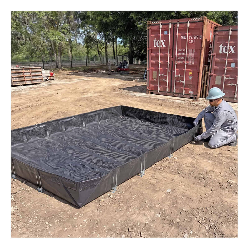A worker in gray attire and a helmet sets up an UltraTech Concrete Washout Berms - RPE Model by UltraTech, a large black reinforced polyethylene berm, on dirt near shipping containers and trees.