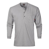 The Saf-Tech 6oz FR Cotton Henley HENL27 in gray is a long-sleeve shirt equipped with a front pocket on the left chest. This flame-resistant garment features a three-button placket and includes a small red tag on the pocket, offering both safety and style in one sleek design.