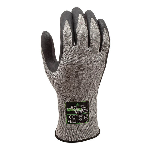 A single SHOWA 386 Cut Resistant Glove by Showa Best stands upright, displaying its gray design with black fingertips and a black cuff. A green and black label with product details is visible on the back of the glove. Equipped with a DURACoil liner for enhanced protection, this glove delivers reliable durability and comfort for demanding tasks.