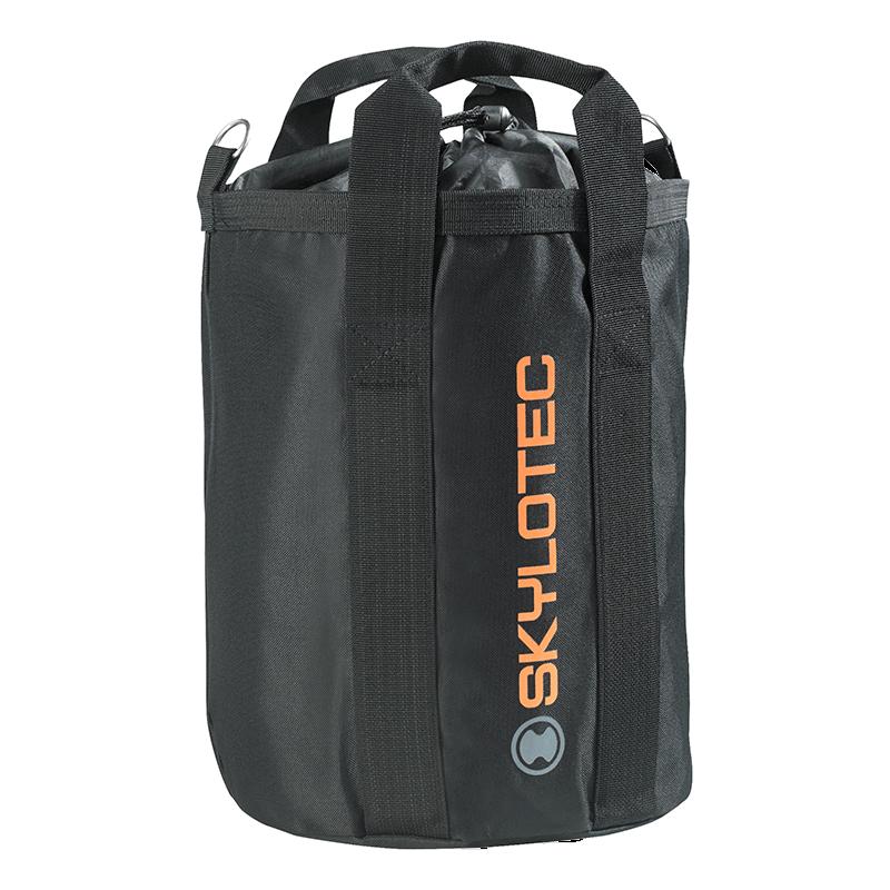 A black cylindrical Skylotec Rope Bag ACS-0009 prominently showcases the "Skylotec" brand in vibrant orange letters on its side. Ideal for climbing rope, it includes sturdy handles and a drawstring closure at the top, keeping your gear secure and easily accessible.