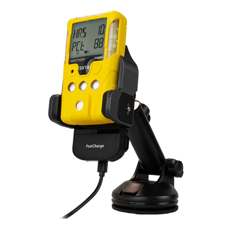 A yellow WatchGas SST Range gas detector with a digital screen sits on the black WatchGas SST Range Wireless Car Charger SST-CAR-CHG, connected by a cable for fast, reliable charging and continuous safety monitoring.