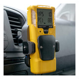 A yellow handheld gas detector with a digital display is mounted in a vehicle near an air vent, beside a WatchGas SST Range Wireless Car Charger SST-CAR-CHG from WatchGas.
