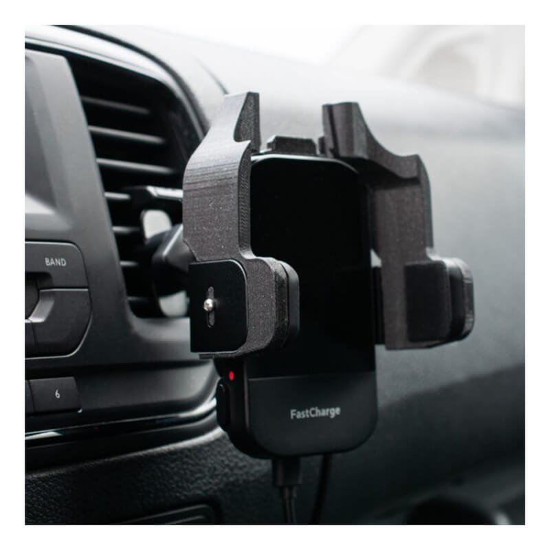 A WatchGas SST Range Wireless Car Charger SST-CAR-CHG by WatchGas holds a black smartphone in a car's air vent mount. "FastCharge" appears at the bottom, with a charging cable attached and the air vent visible in the background.
