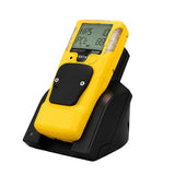 A WatchGas Induction Cradle Charger - Single Desktop w/Adapter holds a yellow gas detector compatible with SST4 and SST5. The device shows gas concentration on its digital display, with front-facing buttons for operation, completing this WatchGas setup.