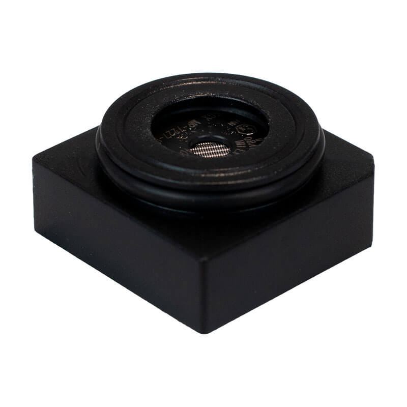 A small, square black plastic object with a round, raised center featuring metallic mesh—it's a WatchGas SST4-PUMP Replacement LPC LEL Sensor (SST-X4-RPL), used in WatchGas gas detectors.