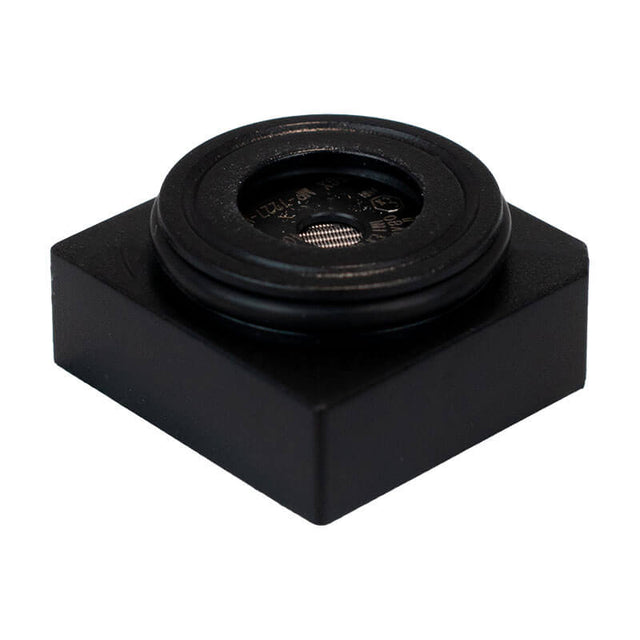 A small, square black plastic object with a round, raised center featuring metallic mesh—it's a WatchGas SST4-PUMP Replacement LPC LEL Sensor (SST-X4-RPL), used in WatchGas gas detectors.