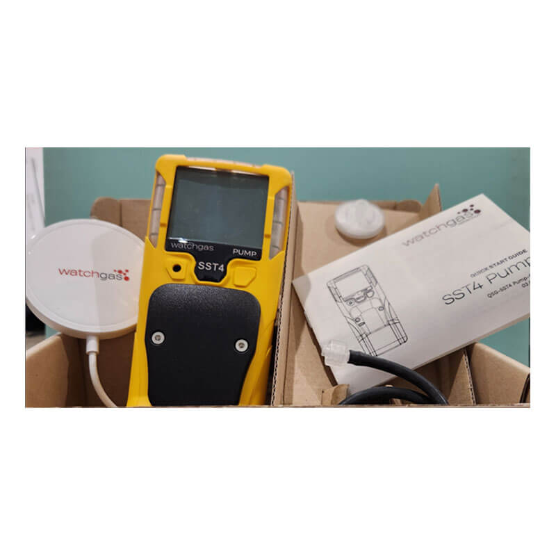 A yellow WatchGas SST4-PUMP 4-gas detector with a black grip, a round white sensor, and a user manual are arranged on a light surface, showcasing reliable gas detection from the brand WatchGas.