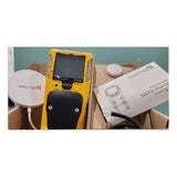 A yellow WatchGas SST4-PUMP 4-gas detector with a black grip, a round white sensor, and a user manual are arranged on a light surface, showcasing reliable gas detection from the brand WatchGas.