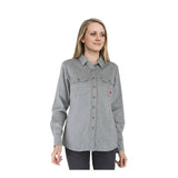 A woman with long blonde hair is wearing the ForgeFR Ladies Knit Shirt LFRB1PS026, an NFPA 2112-certified light gray FR shirt with two chest pockets and dark pants, standing against a plain white background.