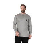 A man with short hair and a beard wears the ForgeFR Forge FR Henley MFRHNLY-004, an NFPA 2112-compliant flame resistant shirt with a buttoned placket and chest pocket, standing against a plain white background.