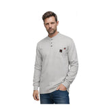 A man wearing the ForgeFR Forge FR Henley MFRHNLY-004 in light gray, featuring a pocket and three buttons, stands with one hand in his jeans pocket against a plain white background.