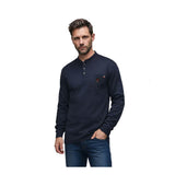A man wears a dark blue ForgeFR Forge FR Henley MFRHNLY-004 with a small chest pocket and blue jeans, standing against a plain white background.