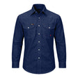 The ForgeFR Solid Shirt Denim MFRSLD-002 from ForgeFR embodies a classic workwear style with its blue denim design, two chest pockets, and white buttons. The shirt features visible stitching and is set against a plain white background, delivering a timeless look that seamlessly complements any flame-resistant clothing collection.