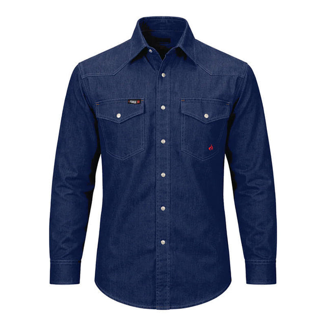The ForgeFR Solid Shirt Denim MFRSLD-002 from ForgeFR embodies a classic workwear style with its blue denim design, two chest pockets, and white buttons. The shirt features visible stitching and is set against a plain white background, delivering a timeless look that seamlessly complements any flame-resistant clothing collection.